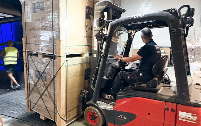 Paletten der Mono S4 Halfcut BC Full Black Module werden mit dem Gabelstapler aus dem LKW geladen.