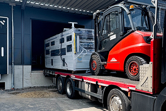 news_artikel_schwertransport-maschinen_factory-one Vortrag Stühle Personen schauen zu Ansicht Rücken