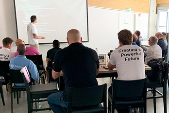 powerday_tile_vortrag_seminar Vortrag Stühle Personen schauen zu Ansicht Rücken